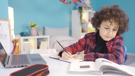 Boy-doing-homework-at-his-desk.-Education-concept.